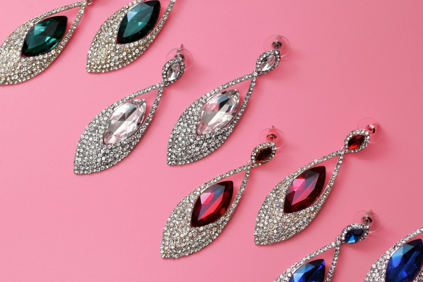 coloured crystal jewellery earrings placed on a pink background