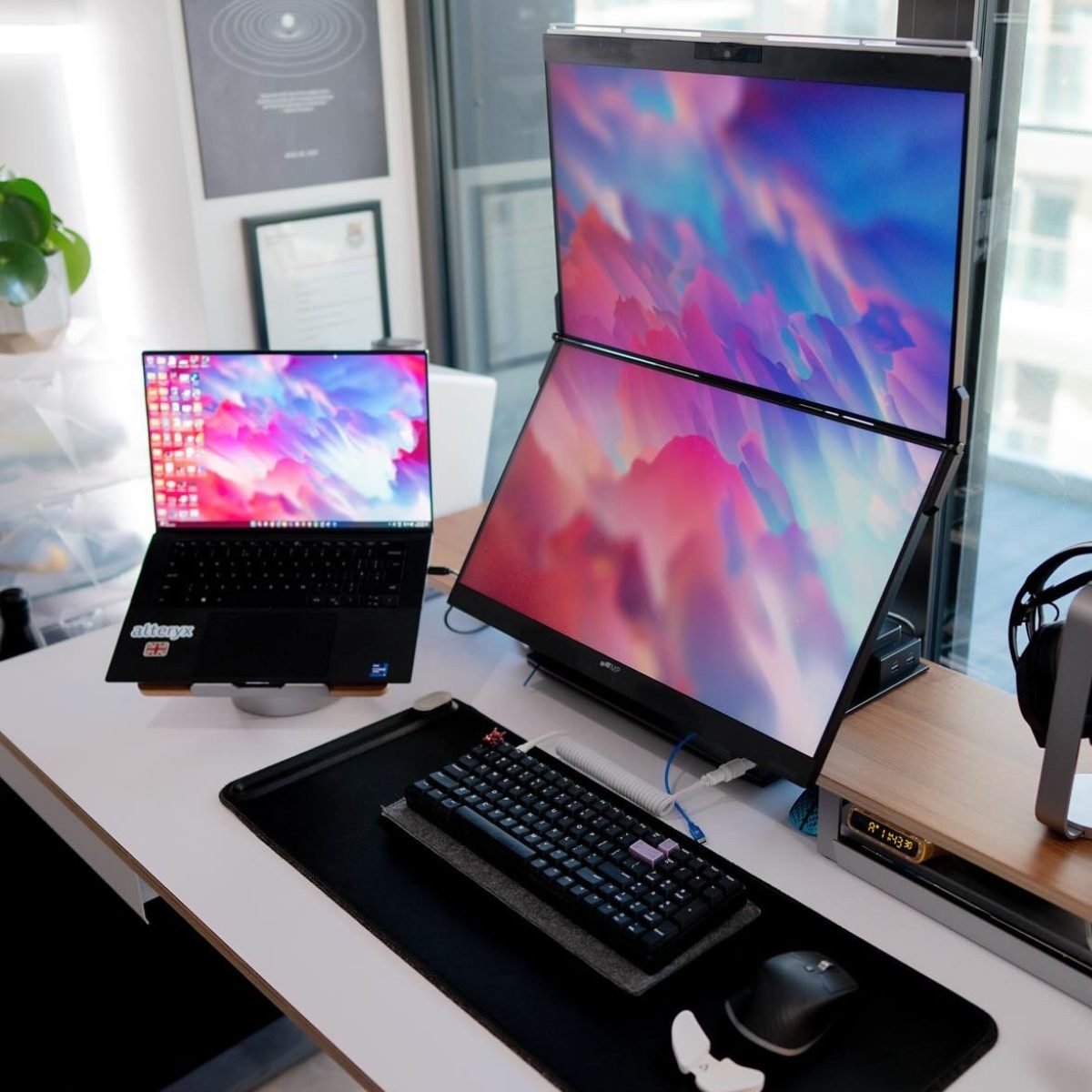 studio set up with three screens, a double extended screen and laptop screen next to it