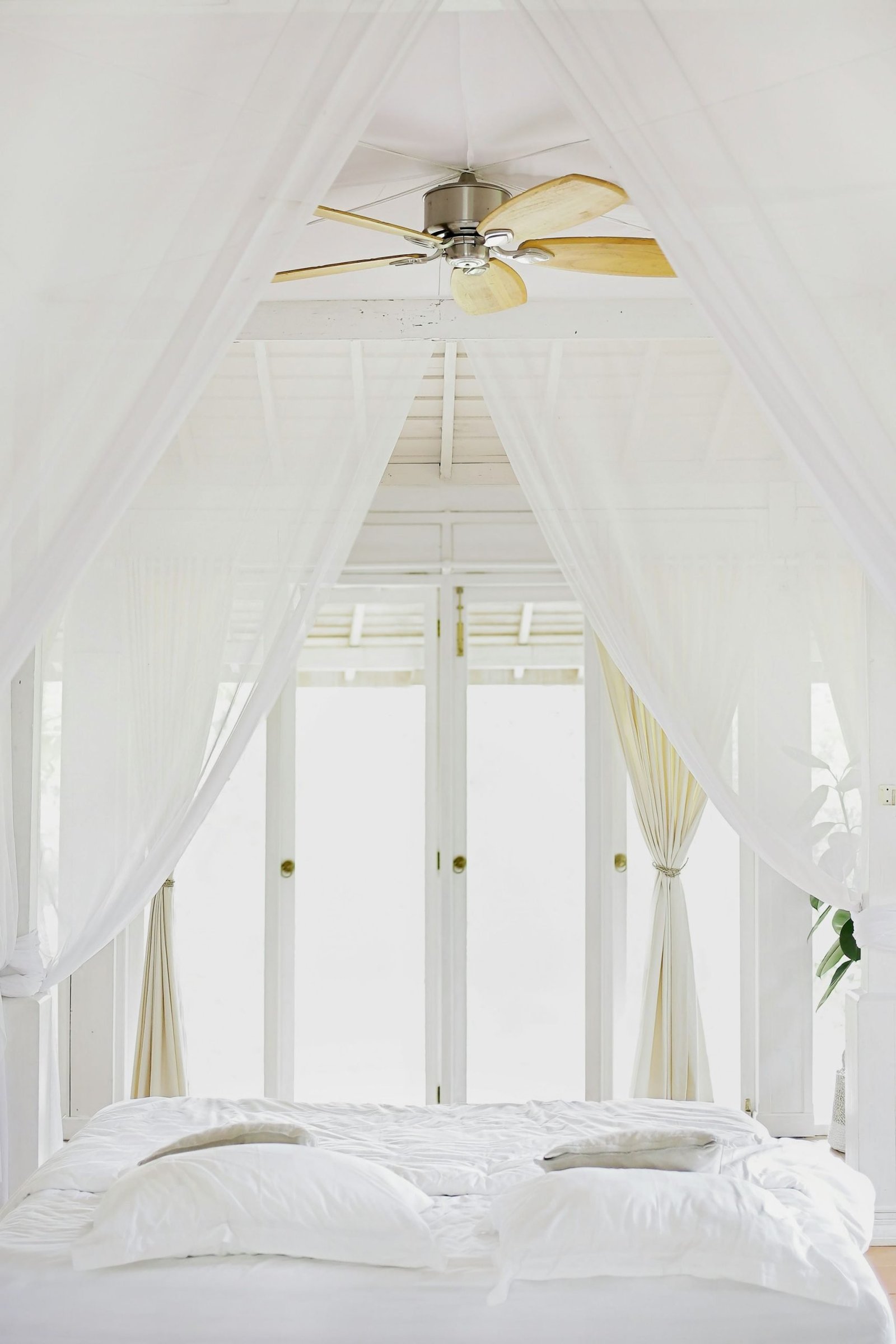 white bedroom canopy revealing a balcony opening