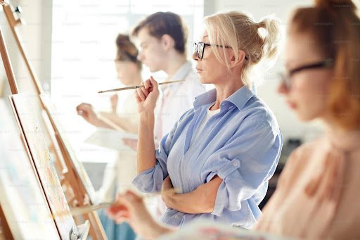 a group of people painting together in a studio