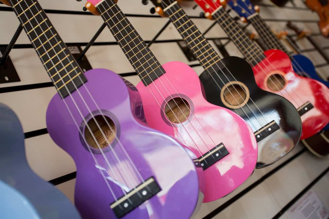 a row of colourful purple pink black and red guitars